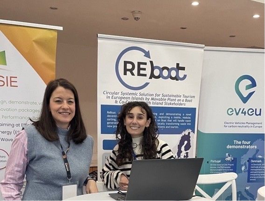 two women smilling to the camera in front of reboat roll-up banner